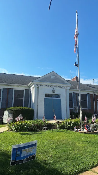 Front of the Prospect Park War Memorial Library with its blue double doors, small flags and flagpole on a sunny day